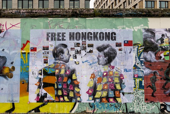 Der chinesische Künstler Badiucao hat ein Bild auf die Rückseite der East Side Gallery geklebt. Damit möchte er auf politische Probleme in seiner Heimat aufmerksam machen.