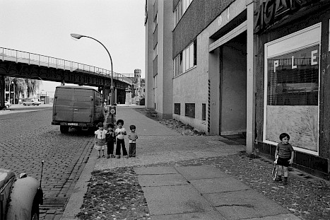 Kinder spielen auf der Straße in der Nähe der Mauer.