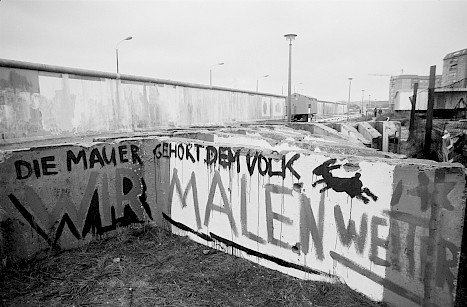 Im Hintergrund ist die geweißte Grenzmauer am Potsdamer Platz zu sehen, vorne der Protest gegen die Übermalung der Bilder der Künstlerinnen und Künstler, November 1989