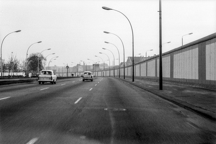 Im Dezember 1989 war zwar die innerdeutsche Grenze schon offen, die Mühlenstraße war jedoch weiterhin eine kahle Hauptverkehrsstraße – auf der einen Seite gerahmt von der grauen Grenzmauer, auf der anderen Seite von den Grundstücksmauern der hier ansässigen Gewerbe und Betriebe